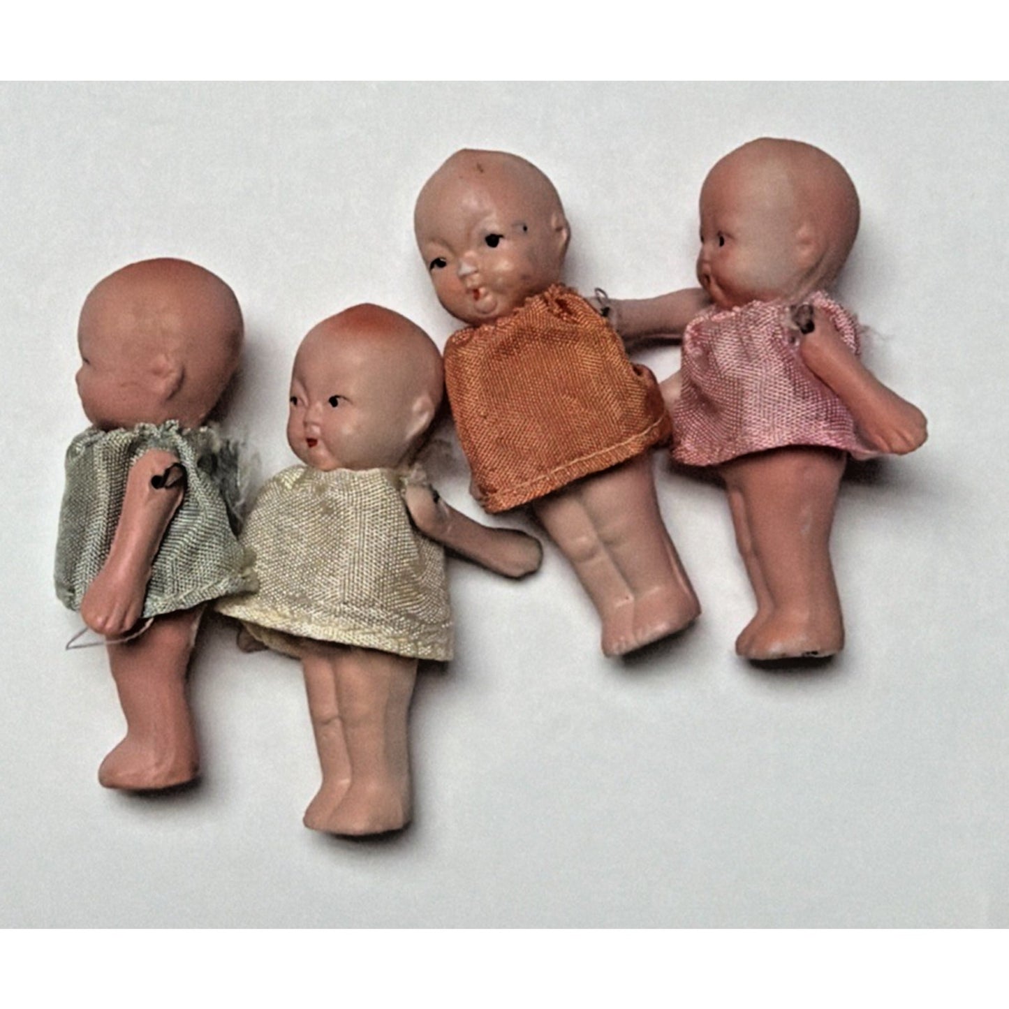 Old Lot of 4 Bisque Porcelain Baby Dolls Miniature Jointed Arms Dresses As Is